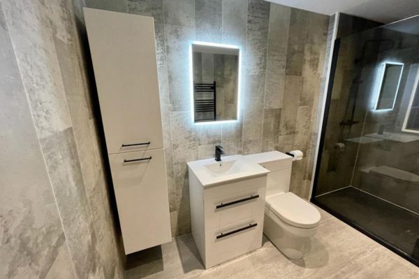 Modern bathroom refurbishment with backlit mirror Gallery Image